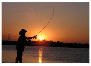 silhouette of person casting a line, fly fishing, at sunset