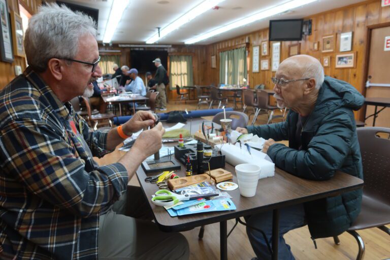 SALTWATER FLY-TYER KEVIN GREEN, left, shares materials and techniques with an interested fly angler at Double Haul Ball.