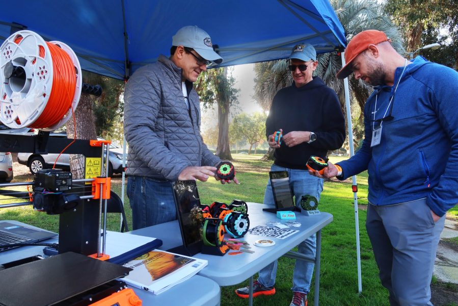 3-D PRINTED FLY-REELS from 3-D Reels are made entirely on the 3-d printer, shown here by Trevor Tanner, left, to interested anglers, Kurt Stockbridge, and Jason Scott, right.
